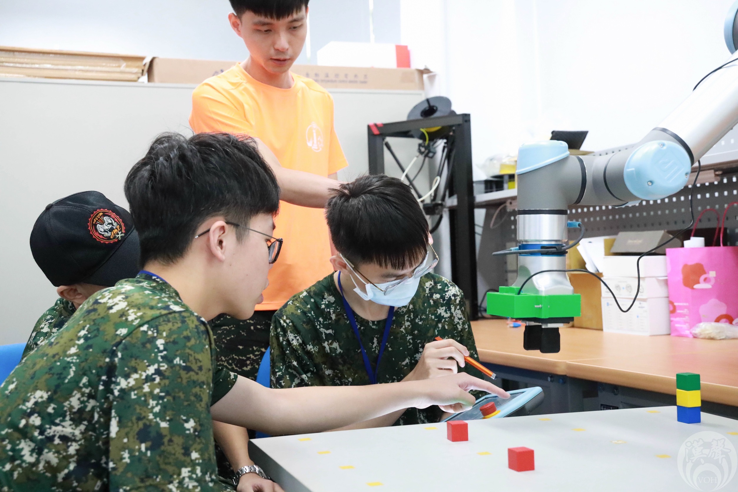 助教協助學員操作機械手臂